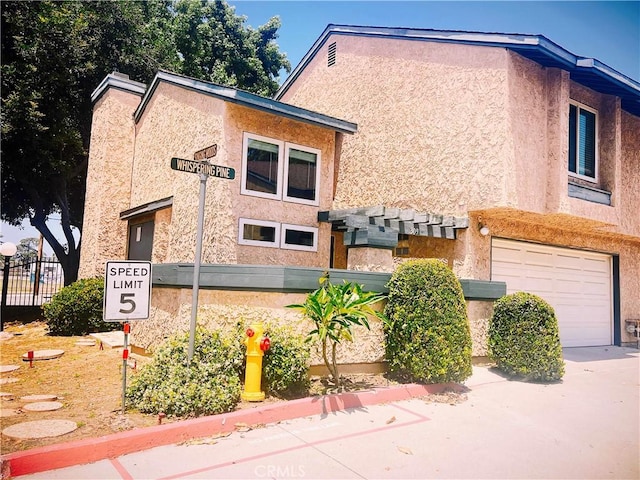 309 Whispering Pine Ln, La Puente, CA 91744 - view of side of property with an attached garage and stucco siding