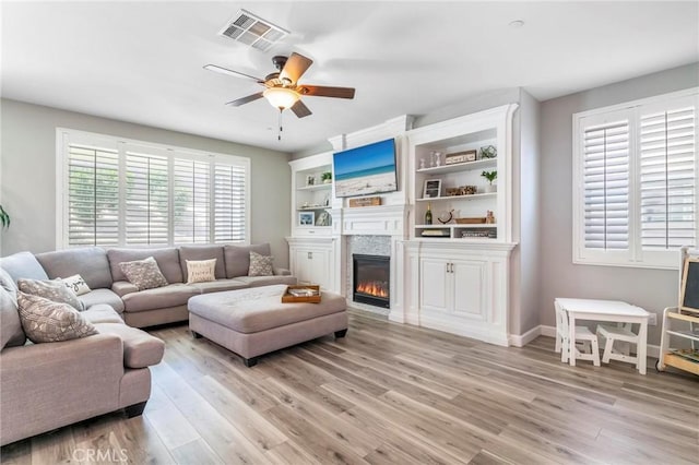 3871 Bur Oak Rd, San Bernardino, CA 92407 - living area with light wood-type flooring, a glass covered fireplace, and ceiling fan