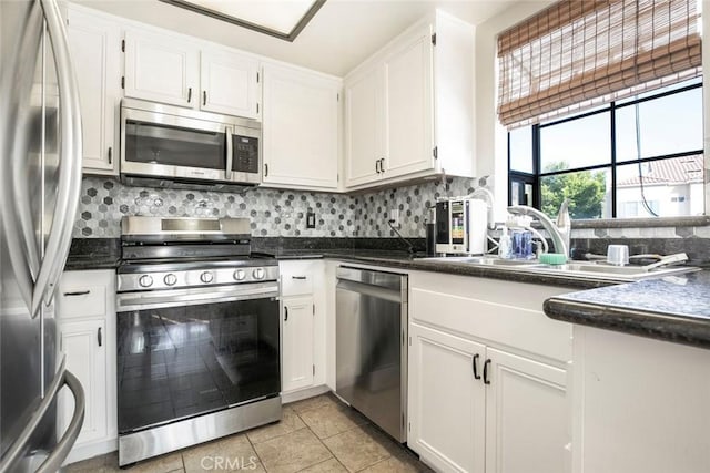 18110 Erik Ct Unit 593, Canyon Country, CA 91387 - kitchen featuring stainless steel appliances, dark countertops, decorative backsplash, white cabinets, and light tile patterned flooring