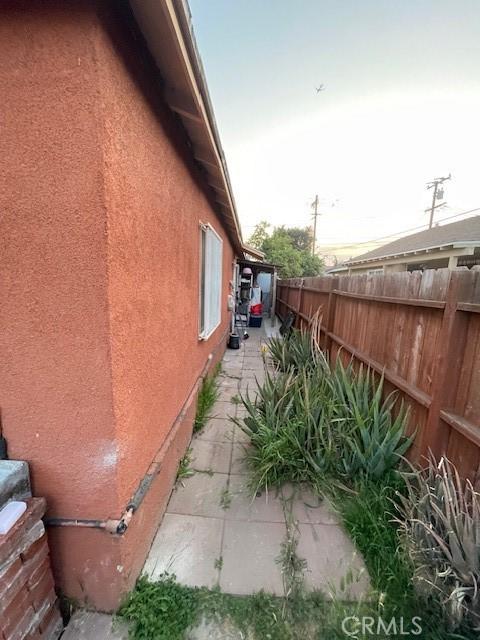 8014 Morton Ave, Los Angeles, CA 90001 - view of side of home with a fenced backyard, a patio, and stucco siding