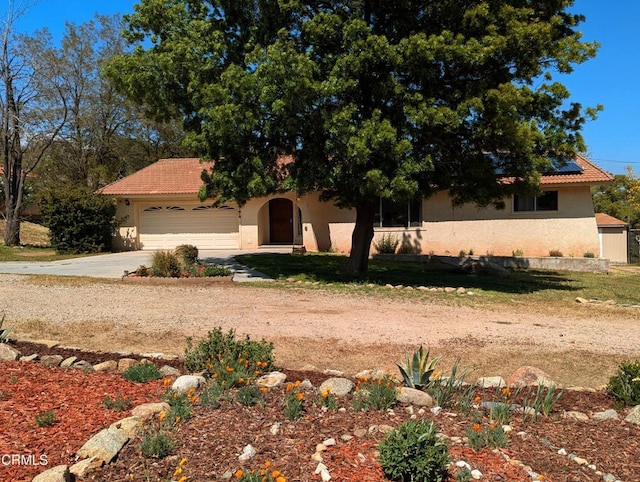 21613 Mountain Dr, Tehachapi, CA 93561 - view of front of property featuring concrete driveway, stucco siding, a garage, and solar panels