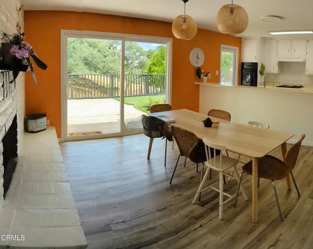 21613 Mountain Dr, Tehachapi, CA 93561 - dining space featuring wood finished floors, plenty of natural light, and a stone fireplace