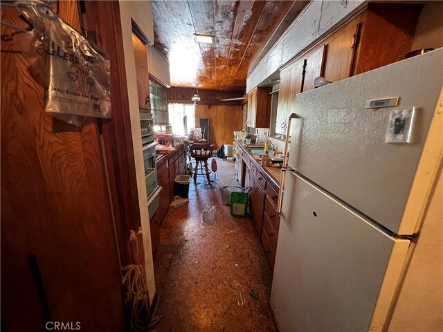 12449 6th St, Yucaipa, CA 92399 - kitchen featuring freestanding refrigerator, brown cabinetry, and wood ceiling