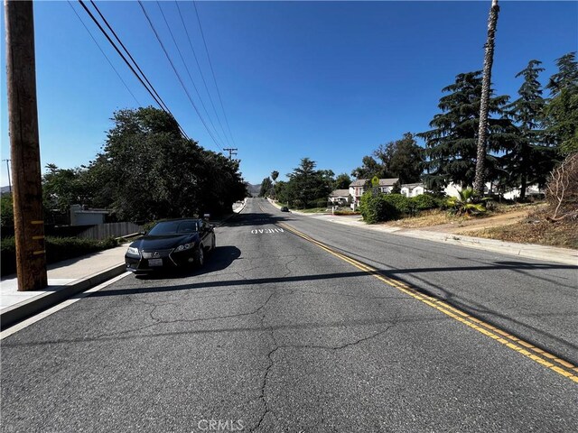 12449 6th St, Yucaipa, CA 92399 - view of asphalt street featuring sidewalks and curbs
