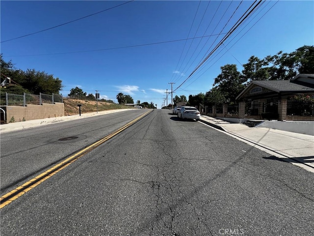 12449 6th St, Yucaipa, CA 92399 - view of asphalt street with sidewalks and curbs