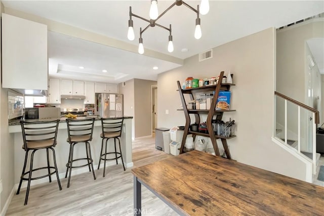 30042 Oceanus, Laguna Niguel, CA 92677 - kitchen with appliances with stainless steel finishes, dark countertops, a peninsula, light wood-style flooring, and recessed lighting