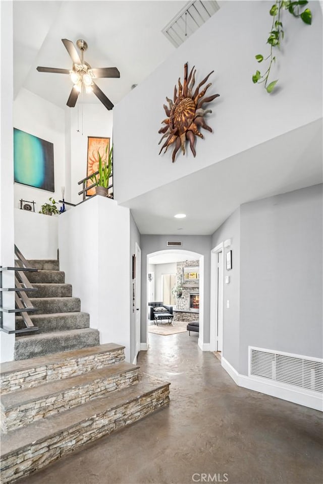 36536 Jenna Ln, Palmdale, CA 93550 - stairway with arched walkways, finished concrete floors, a ceiling fan, and a high ceiling