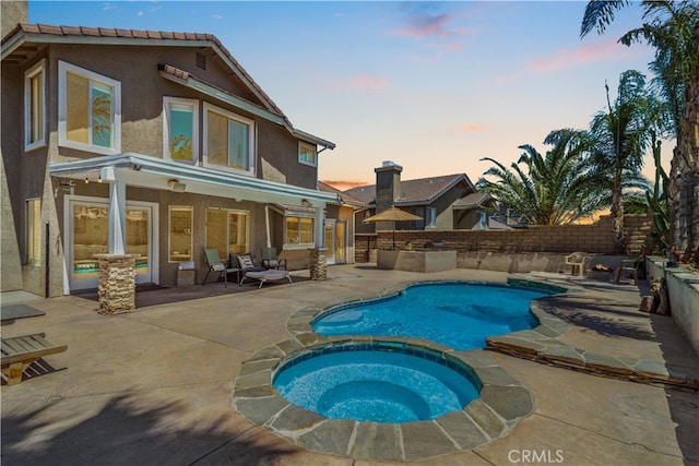 36536 Jenna Ln, Palmdale, CA 93550 - back of property at dusk with stucco siding, a patio area, a fenced backyard, and a pool with connected hot tub