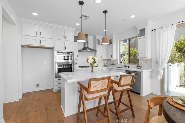 3173 Ivy Way, Rancho Mission Viejo, CA 92694 - kitchen featuring appliances with stainless steel finishes, wall chimney exhaust hood, white cabinetry, light countertops, and recessed lighting