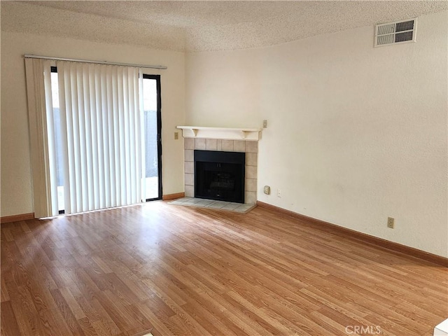 22790 Lakeway Dr Unit 461, Diamond Bar, CA 91765 - unfurnished living room with a textured ceiling, wood finished floors, and a tiled fireplace