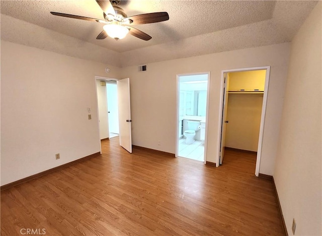 22790 Lakeway Dr Unit 461, Diamond Bar, CA 91765 - unfurnished bedroom with light wood finished floors, a walk in closet, a textured ceiling, ensuite bathroom, and a closet