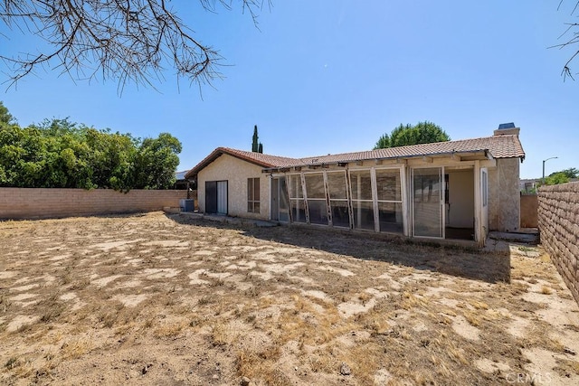 44668 13th St E, Lancaster, CA 93535 - rear view of property featuring a chimney, a tiled roof, stucco siding, a sunroom, and a fenced backyard