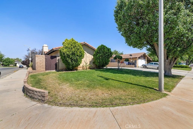 44668 13th St E, Lancaster, CA 93535 - obstructed view of property with a front lawn and stucco siding