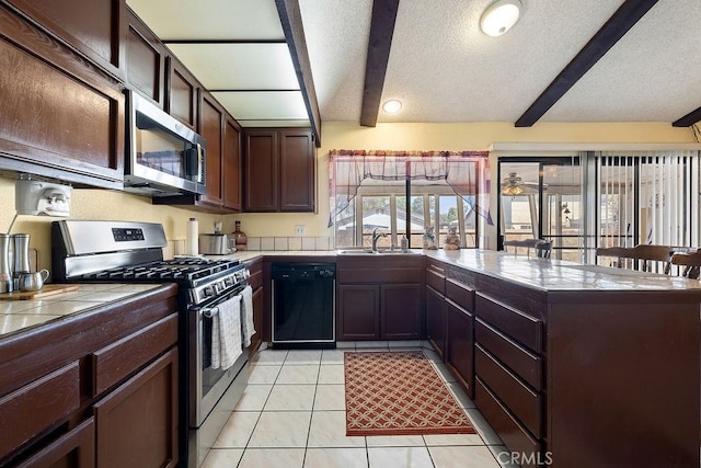 44668 13th St E, Lancaster, CA 93535 - kitchen with stainless steel appliances, a peninsula, a textured ceiling, tile counters, and light tile patterned floors