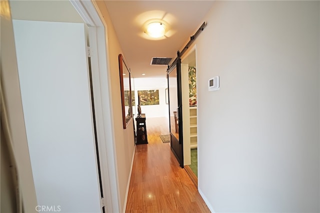 1525 N Hayworth Ave Unit 304, Los Angeles, CA 90046 - corridor featuring a barn door and light wood-style floors