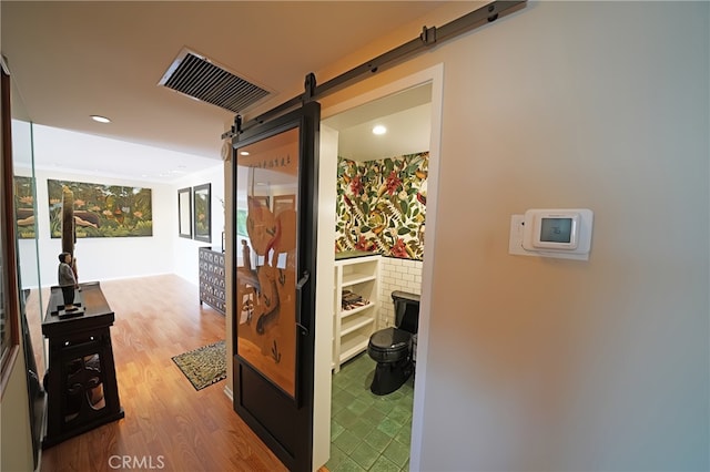 1525 N Hayworth Ave Unit 304, Los Angeles, CA 90046 - corridor featuring a barn door, wood finished floors, and recessed lighting