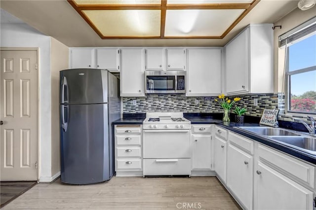 13303 Waco St Unit 32, Baldwin Park, CA 91706 - kitchen with stainless steel appliances, dark countertops, backsplash, and white cabinetry