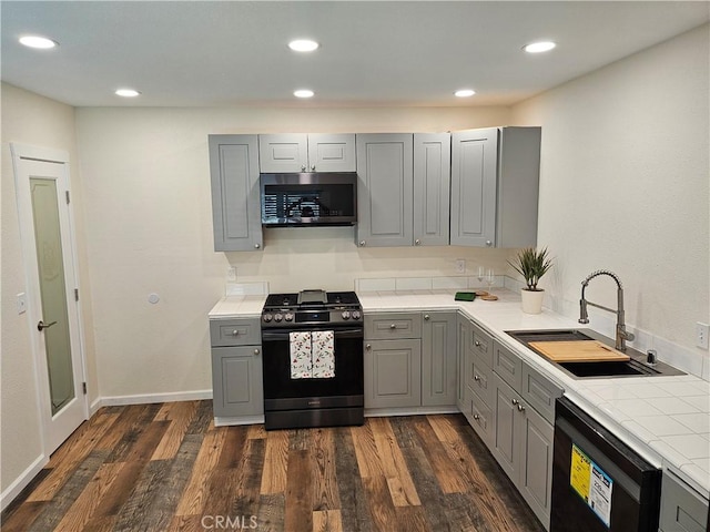 8463 California Ave, Riverside, CA 92504 - kitchen with gray cabinetry, range with gas stovetop, stainless steel microwave, dishwasher, and tile counters