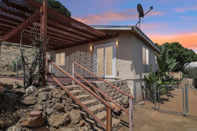 1230 Ramona Ave, Spring Valley, CA 91977 - property exterior at dusk featuring a gate, a pergola, and stucco siding