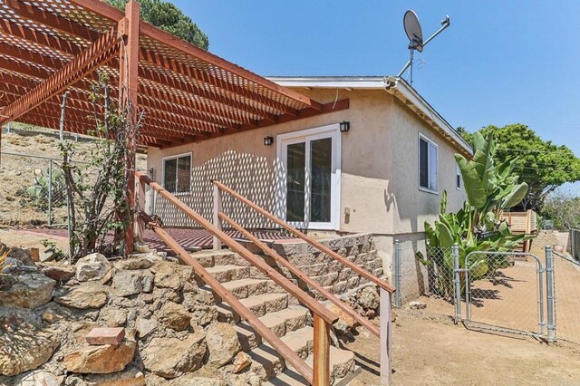 1230 Ramona Ave, Spring Valley, CA 91977 - back of property with a gate, stucco siding, and a pergola