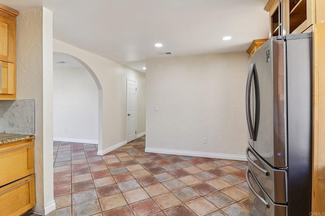 1230 Ramona Ave, Spring Valley, CA 91977 - kitchen with freestanding refrigerator, arched walkways, recessed lighting, and light stone counters