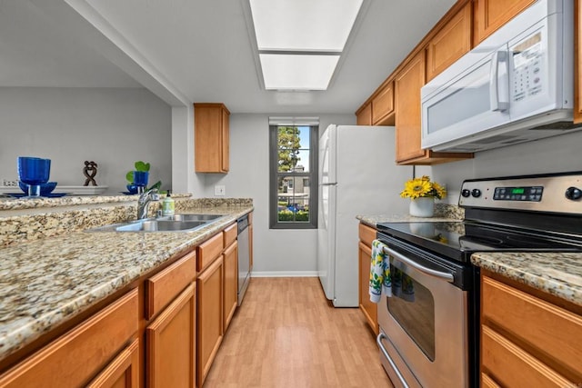 15032 Avenida Venusto Unit 179, San Diego, CA 92128 - kitchen with appliances with stainless steel finishes, brown cabinets, light wood finished floors, and light stone countertops