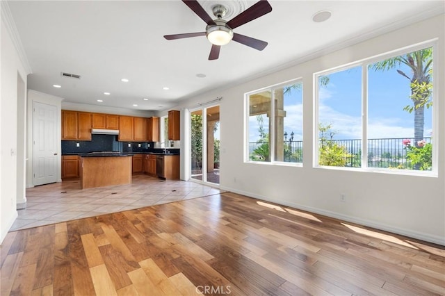 24058 Via Vis, Valencia, CA 91354 - kitchen with dark countertops, ornamental molding, open floor plan, brown cabinets, and recessed lighting