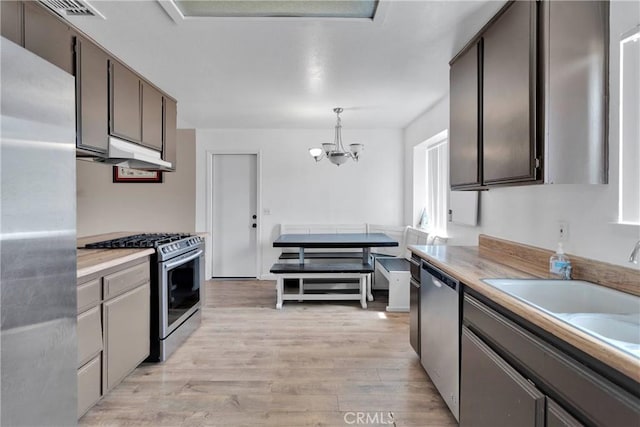 8960 Buckthorn Ave, Hesperia, CA 92345 - kitchen with appliances with stainless steel finishes, light wood-type flooring, light countertops, and a chandelier