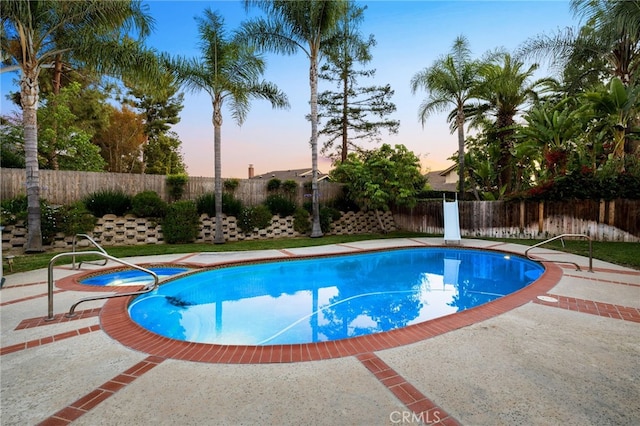 1722 Calle Alto, San Dimas, CA 91773 - pool at dusk with a fenced backyard, a pool with connected hot tub, and a patio area
