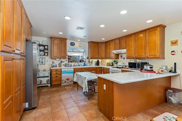 1117 Gladstone St, La Verne, CA 91750 - kitchen featuring stainless steel appliances, a peninsula, brown cabinets, recessed lighting, and light countertops