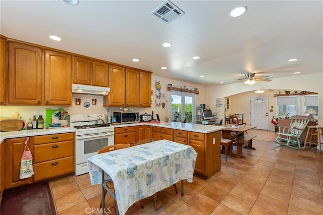 1117 Gladstone St, La Verne, CA 91750 - kitchen with gas range gas stove, under cabinet range hood, a peninsula, stainless steel microwave, and light countertops
