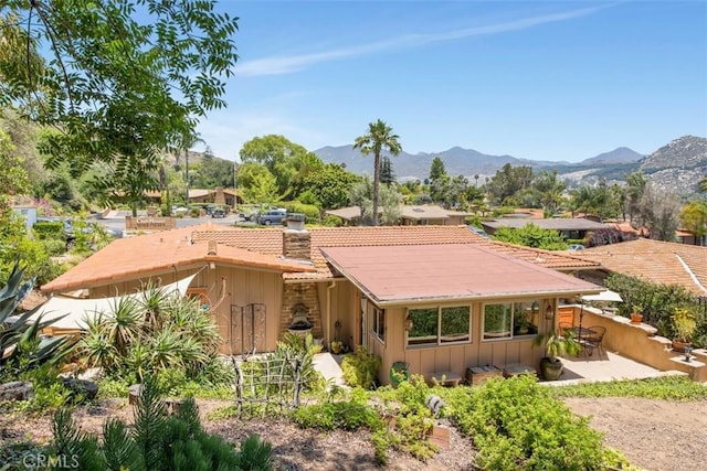 3331 Via Altamira, Fallbrook, CA 92028 - rear view of house with a chimney, board and batten siding, a mountain view, and a patio area