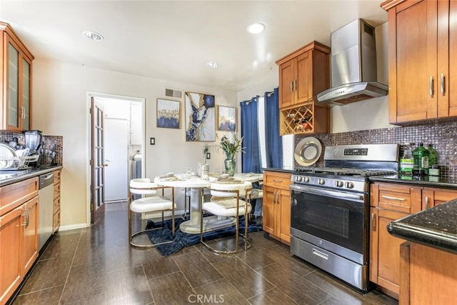 3432 Larissa Dr, Los Angeles, CA 90026 - kitchen with appliances with stainless steel finishes, wall chimney exhaust hood, backsplash, brown cabinetry, and glass insert cabinets