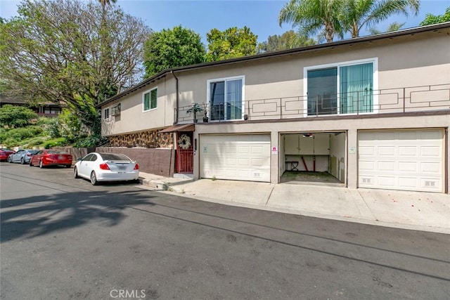 3432 Larissa Dr, Los Angeles, CA 90026 - multi unit property featuring stucco siding, a balcony, an attached garage, and driveway