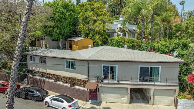 3432 Larissa Dr, Los Angeles, CA 90026 - rear view of house featuring a garage, roof with shingles, stucco siding, and driveway