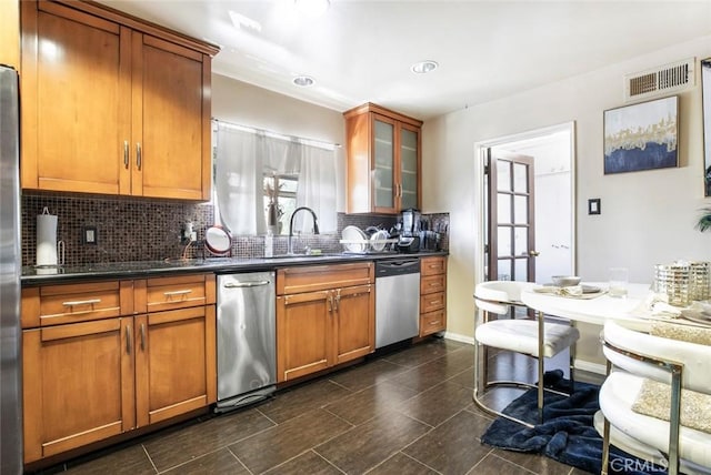 3432 Larissa Dr, Los Angeles, CA 90026 - kitchen featuring stainless steel appliances, backsplash, brown cabinetry, glass insert cabinets, and dark countertops