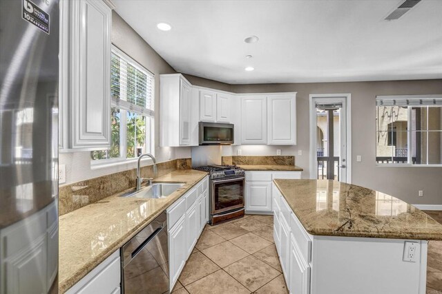 13325 Via Tresca Unit 7, San Diego, CA 92129 - kitchen featuring appliances with stainless steel finishes, a kitchen island, white cabinets, light stone counters, and recessed lighting
