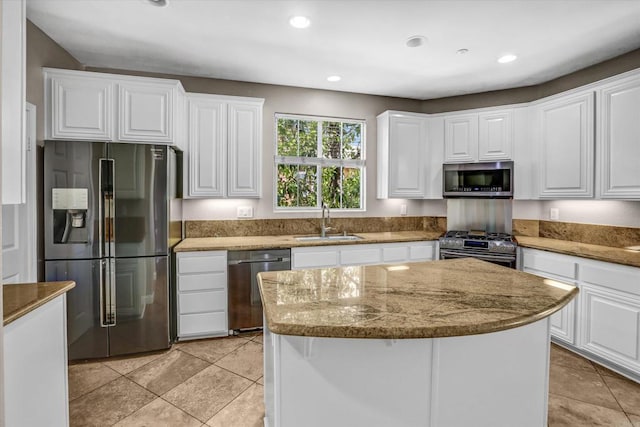 13325 Via Tresca Unit 7, San Diego, CA 92129 - kitchen with appliances with stainless steel finishes, a kitchen island, white cabinetry, light stone counters, and recessed lighting
