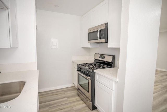 1925 Ginger St Unit 112, Oxnard, CA 93036 - kitchen with stainless steel appliances, light wood finished floors, and white cabinetry