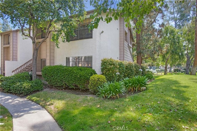 26701 Quail Crk Unit 31, Laguna Hills, CA 92656 - view of property exterior featuring a yard and stucco siding