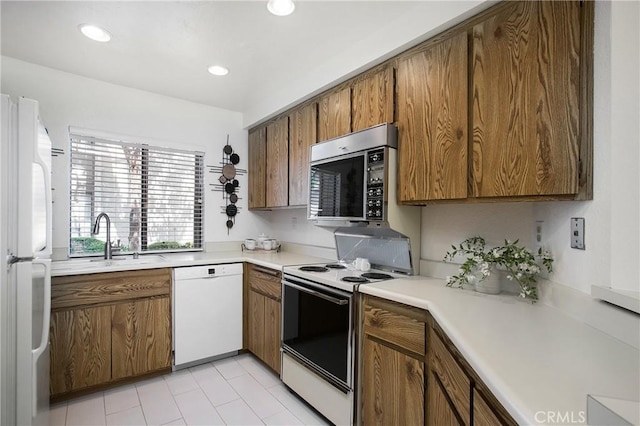 26701 Quail Crk Unit 31, Laguna Hills, CA 92656 - kitchen with white appliances, brown cabinets, light countertops, recessed lighting, and light tile patterned floors