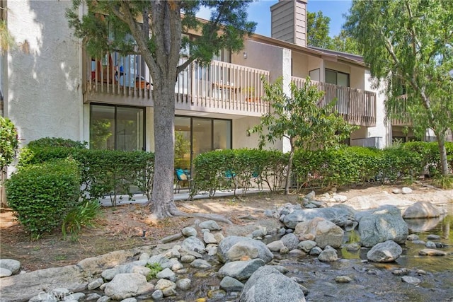 26701 Quail Crk Unit 31, Laguna Hills, CA 92656 - back of house featuring stucco siding, a chimney, and a balcony