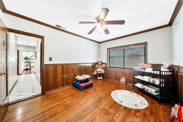 520 W Santa Clara Ave, Santa Ana, CA 92706 - interior space with wood finished floors, wainscoting, a ceiling fan, arched walkways, and wooden walls
