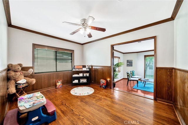 520 W Santa Clara Ave, Santa Ana, CA 92706 - living room featuring a wainscoted wall, wood finished floors, a ceiling fan, and wood walls