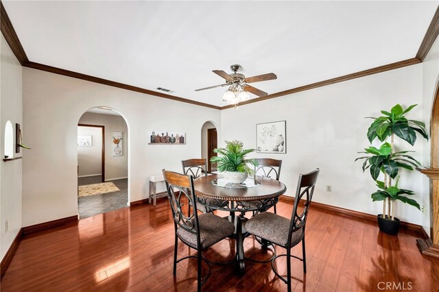 520 W Santa Clara Ave, Santa Ana, CA 92706 - dining area with arched walkways, a ceiling fan, dark wood-type flooring, and crown molding