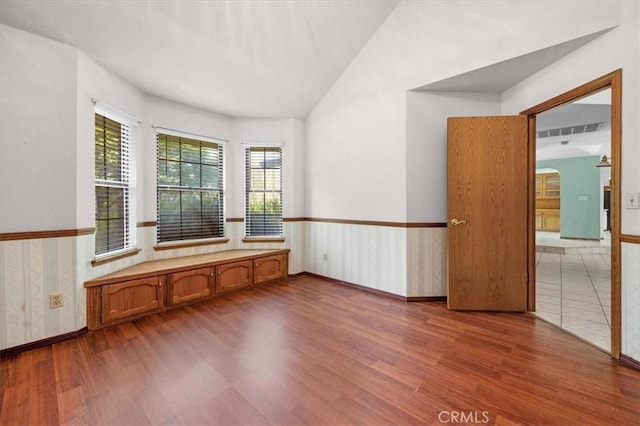 6710 Golden State Blvd, Madera, CA 93637 - spare room with wood finished floors, vaulted ceiling, and a wainscoted wall