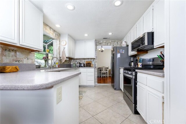 6255 Barranca Dr, Riverside, CA 92506 - kitchen with appliances with stainless steel finishes, white cabinetry, light tile patterned floors, decorative backsplash, and recessed lighting