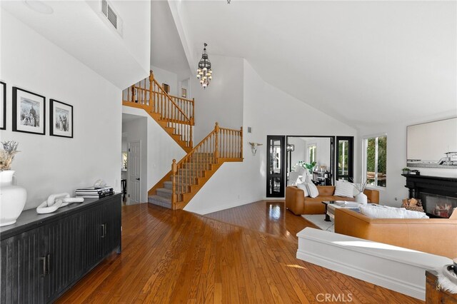 12026 Haven Crest St, Moorpark, CA 93021 - living room featuring high vaulted ceiling, stairs, hardwood / wood-style floors, and a chandelier