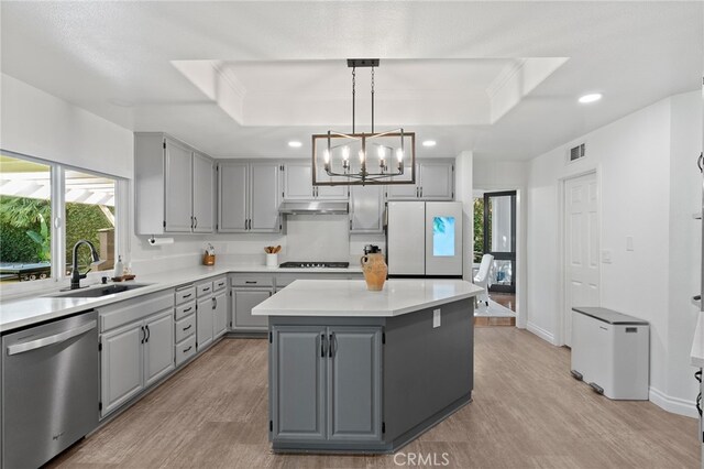 12026 Haven Crest St, Moorpark, CA 93021 - kitchen with stainless steel dishwasher, gray cabinets, freestanding refrigerator, a raised ceiling, and light wood-type flooring
