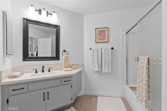 12026 Haven Crest St, Moorpark, CA 93021 - full bathroom featuring vanity, shower / bath combination with glass door, and wood finished floors